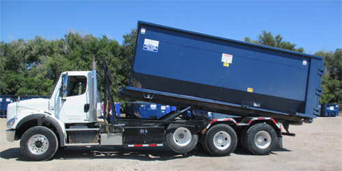 Photo of roll-off truck unloading roll-off bin.